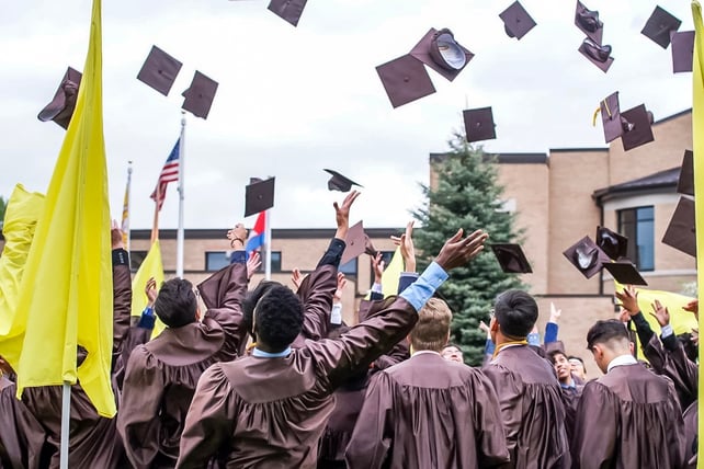 boys throwing graduation caps