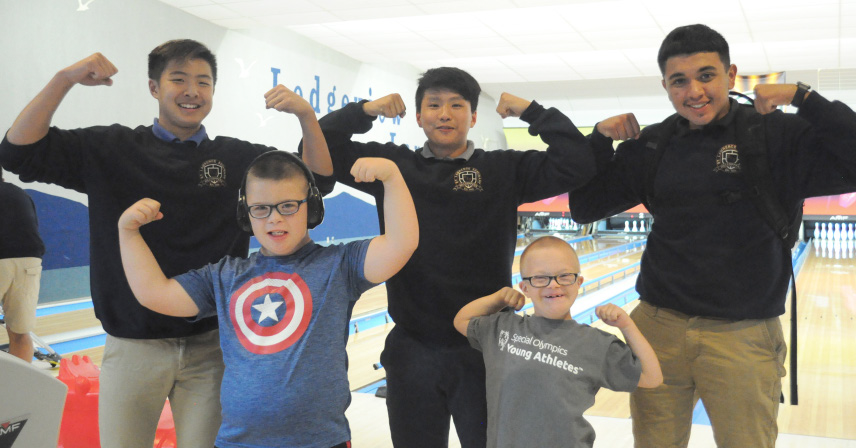 a group of boys posing together at a bowling alley