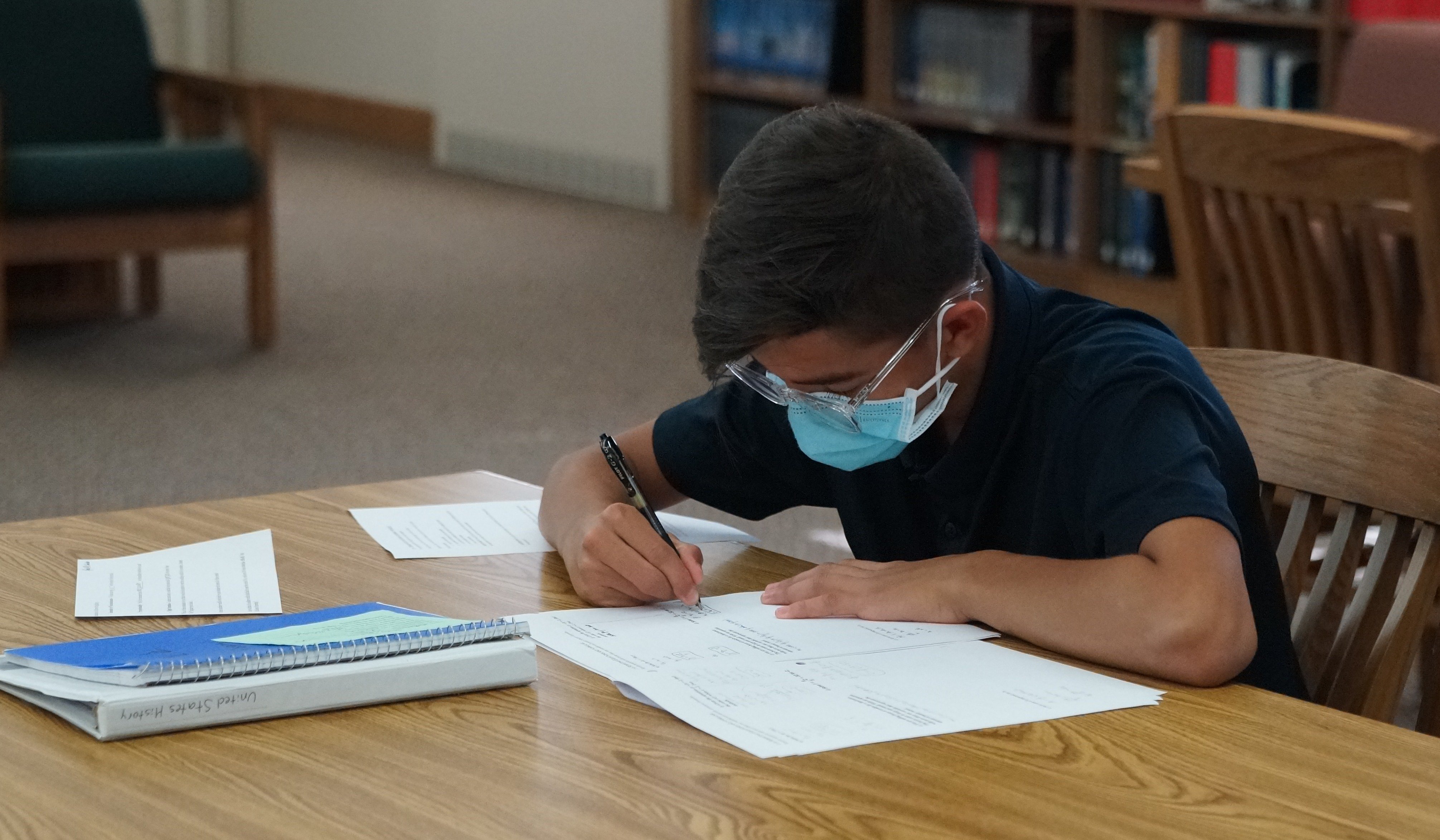 a young boy studying at a desk