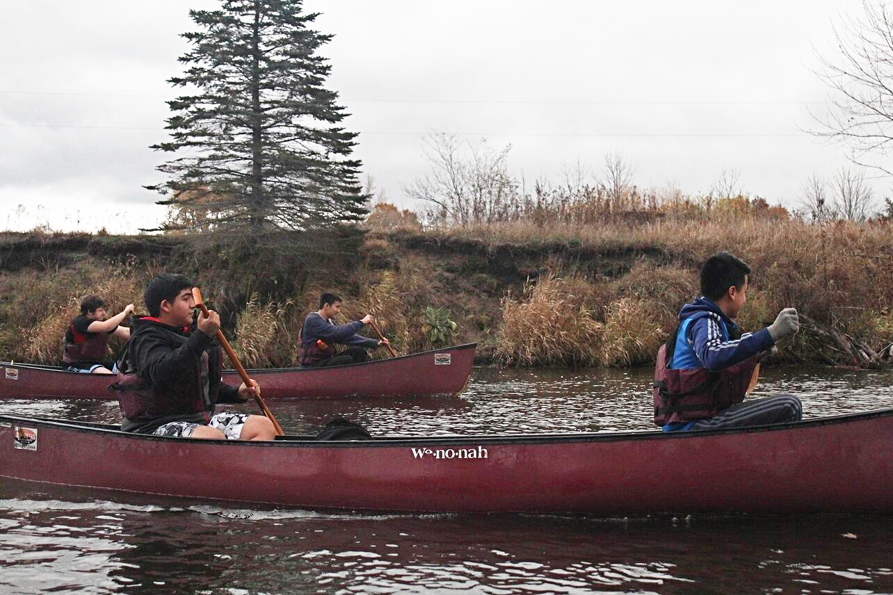 boys rowing in a canoe