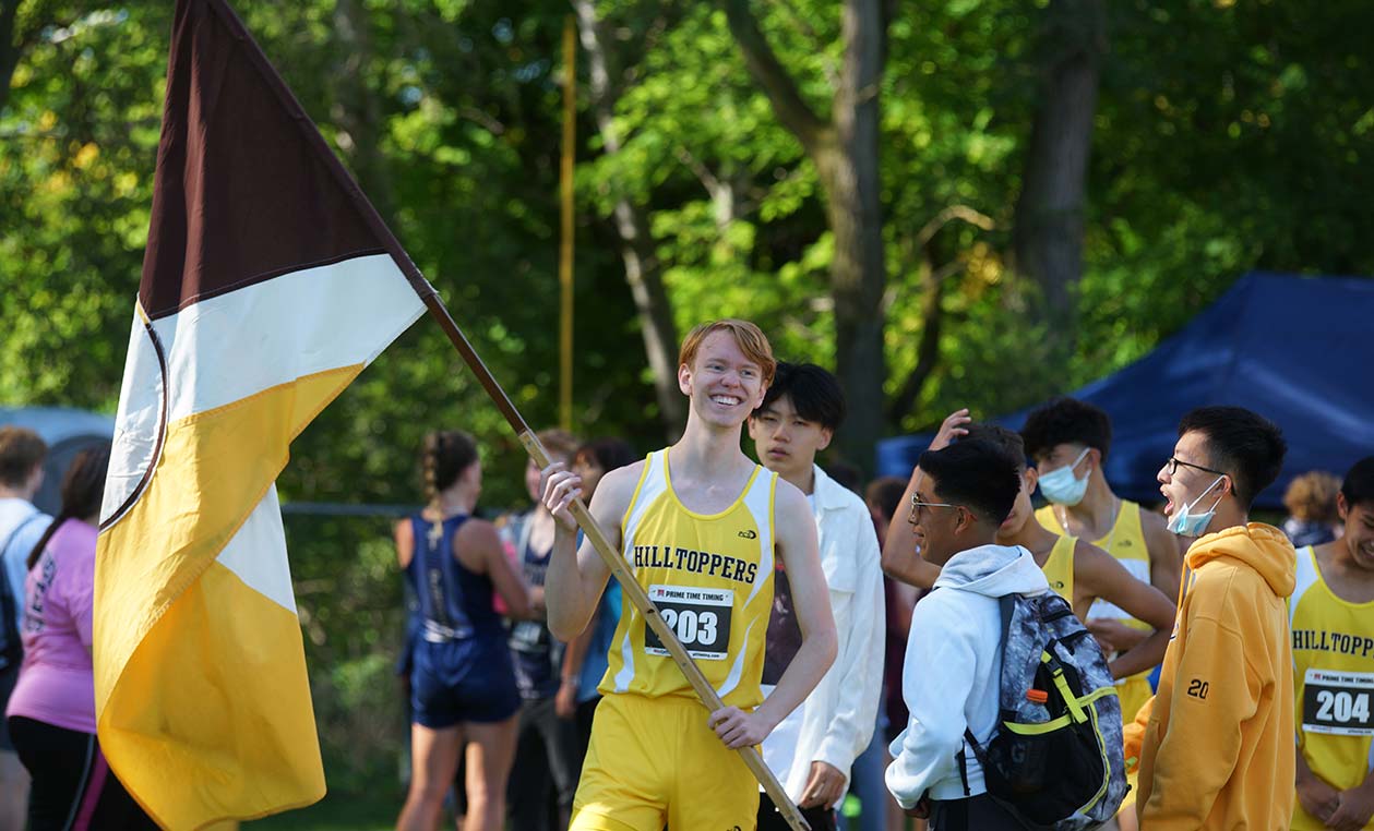 Student Holding Flag at Cross Country Meet